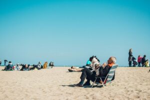 Elderly man with dog enjoying a sunny day at the beach in Barcelona, Spain.