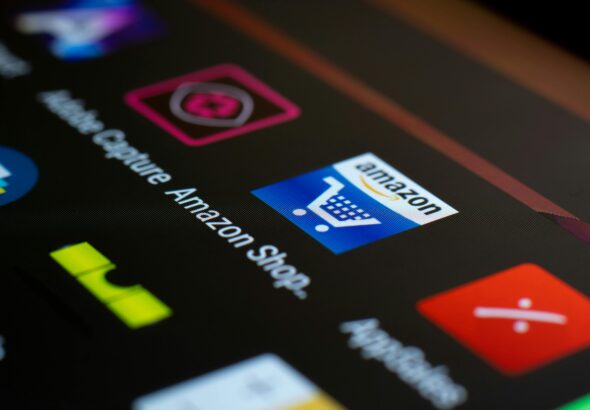 Close-up of the Amazon shopping app icon on a smartphone screen. Ideal for online shopping and technology themes.